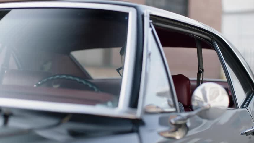 A man waiting inside his car after turning off the engine