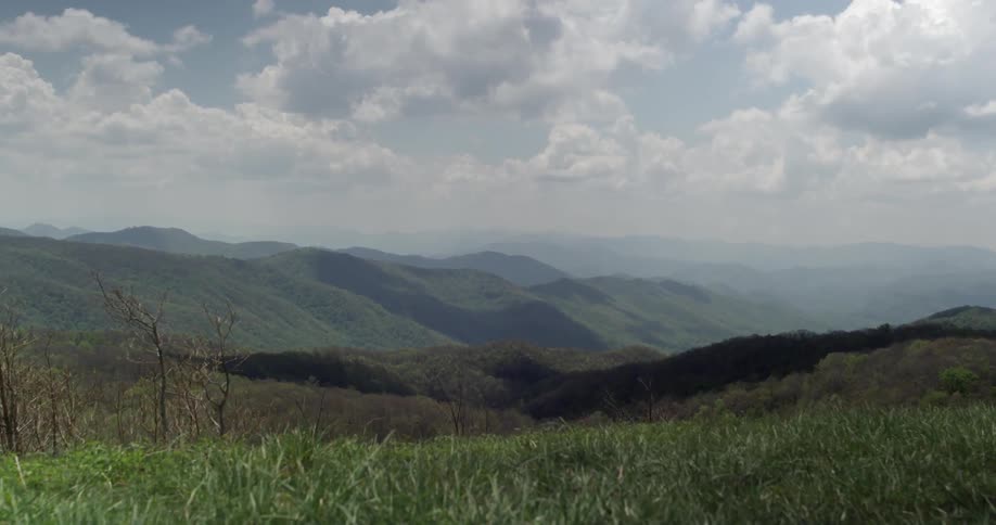 A large hillside is covered in grass on a cloudy day