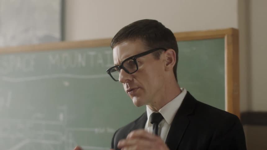 Teacher lectures near chalkboard