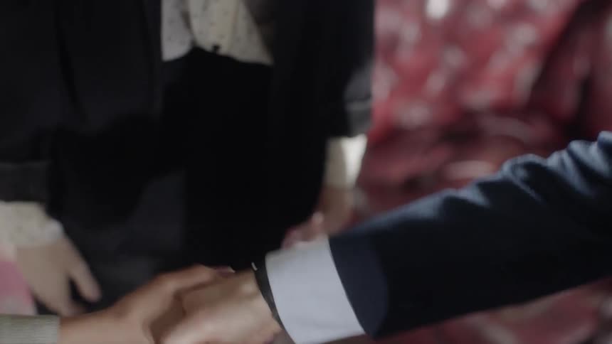 Three people shake hands