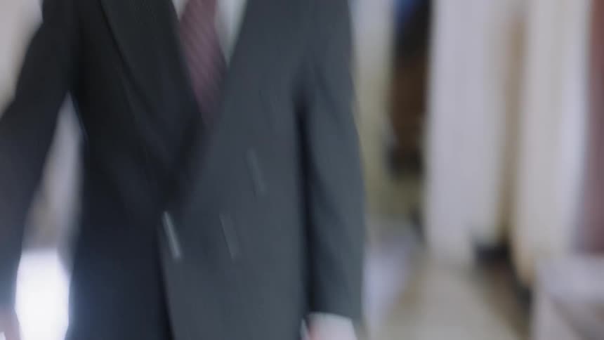 A man with a briefcase walking down a hallway