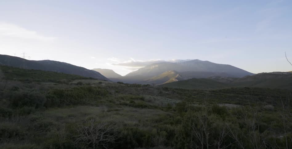 A cloud hovers over a mountain in the wilderness