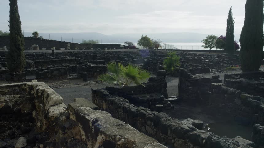 The stone ruins are abandoned and have accumulated mud and puddles after a recent rain