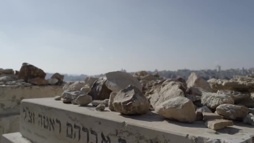 Slabs of cement with symbols and letters on the side with rocks piled on top