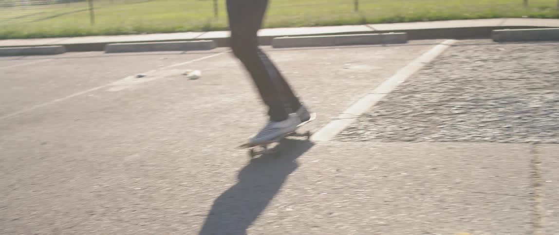 Man rides a skateboard in a parking lot