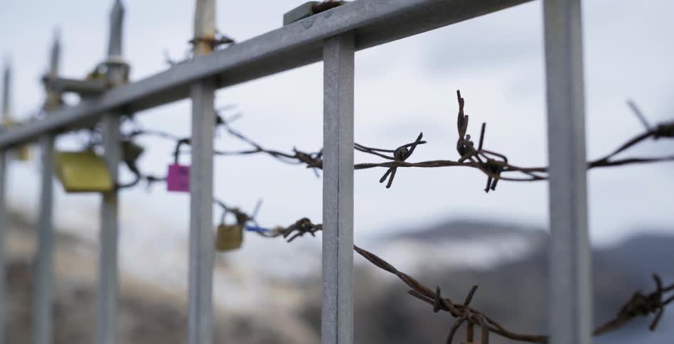 A iron fence with barbed wire on it