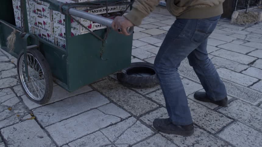 A man pushes a car filled with boxes