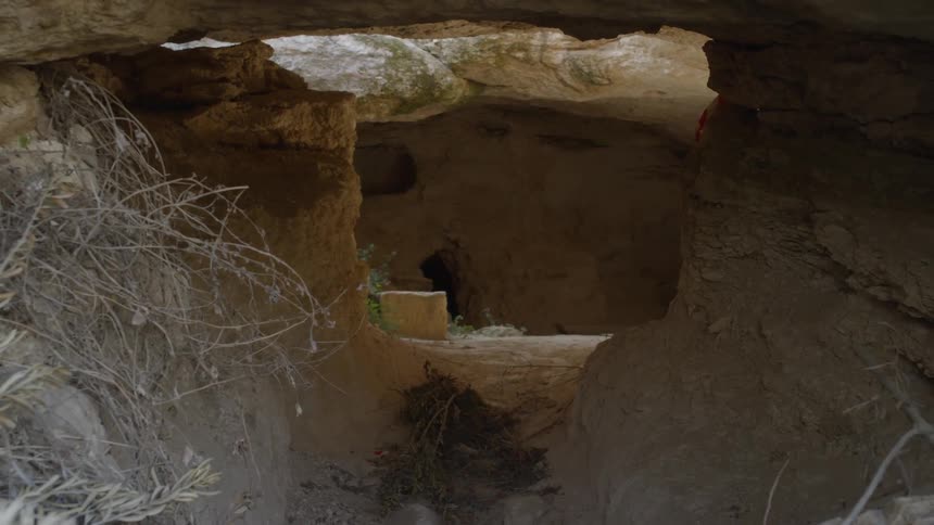 A cave surrounded by dry grass