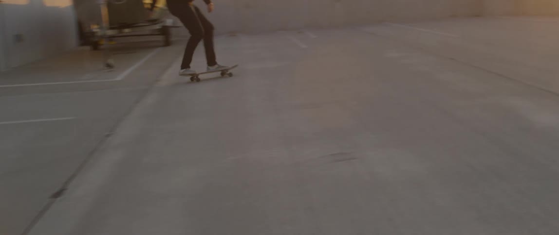 Person hops on and rides a skateboard to a wall