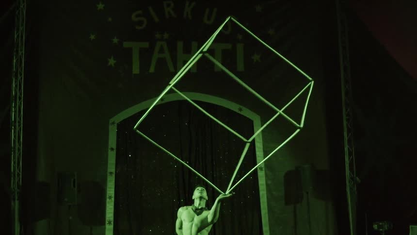 A man twirls a large empty cube