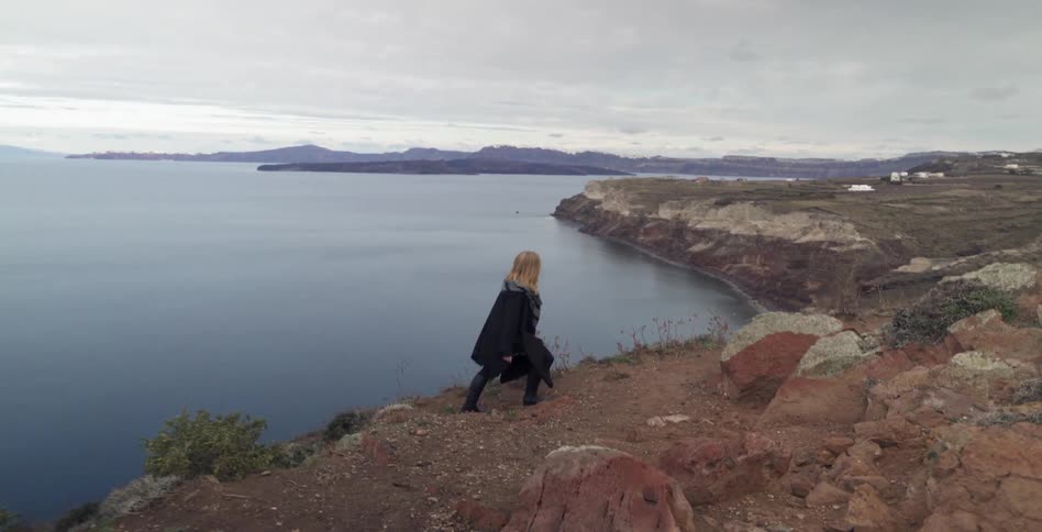 A woman walks by a large lake