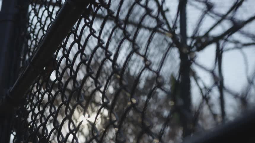 Blurry chain link fence with sun shining through it