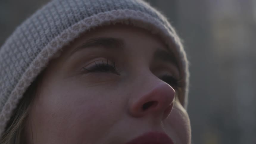 A white woman in a skull cap looking up at the sky
