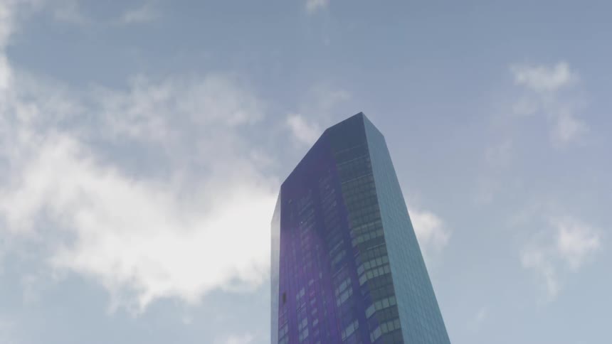 Clouds float above a city skyscraper