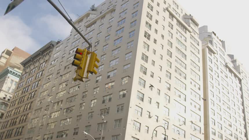 Birds fly across a built up intersection in daylight