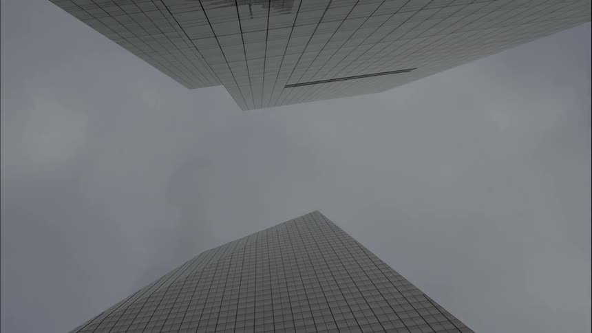 Looking up between two buildings in to a cloudy sky