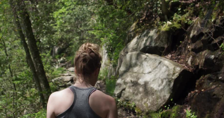 A woman hikes through a forest trail