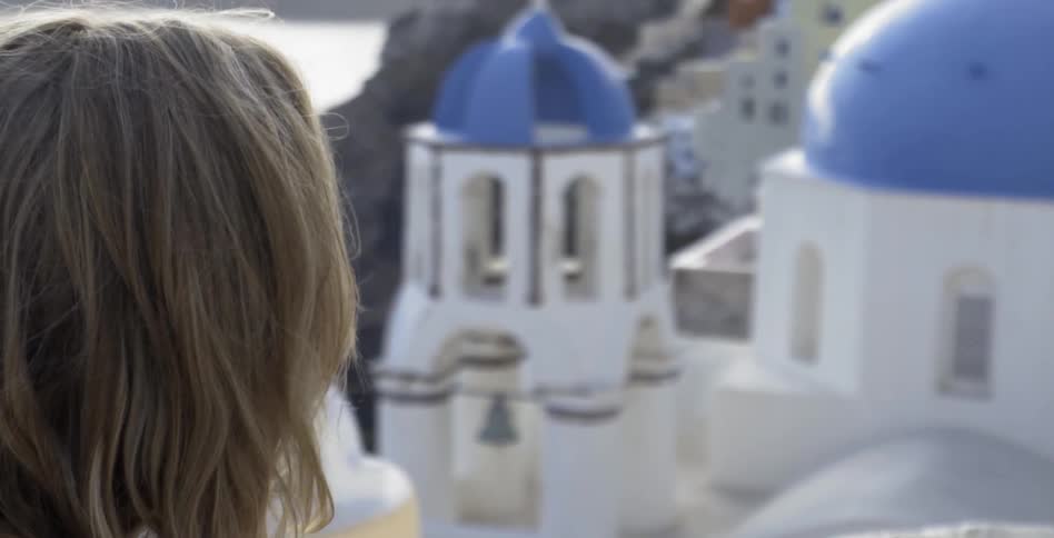 Blonde woman looking at buildings at a seaside beach