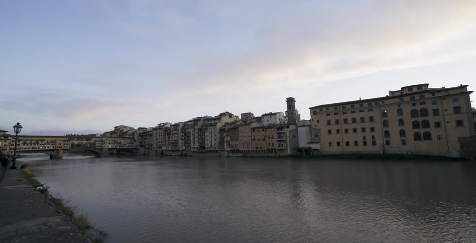 Water flows down a city canal at dawn