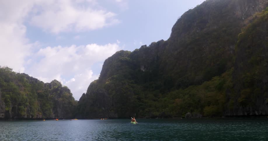 People in the water by a cliff