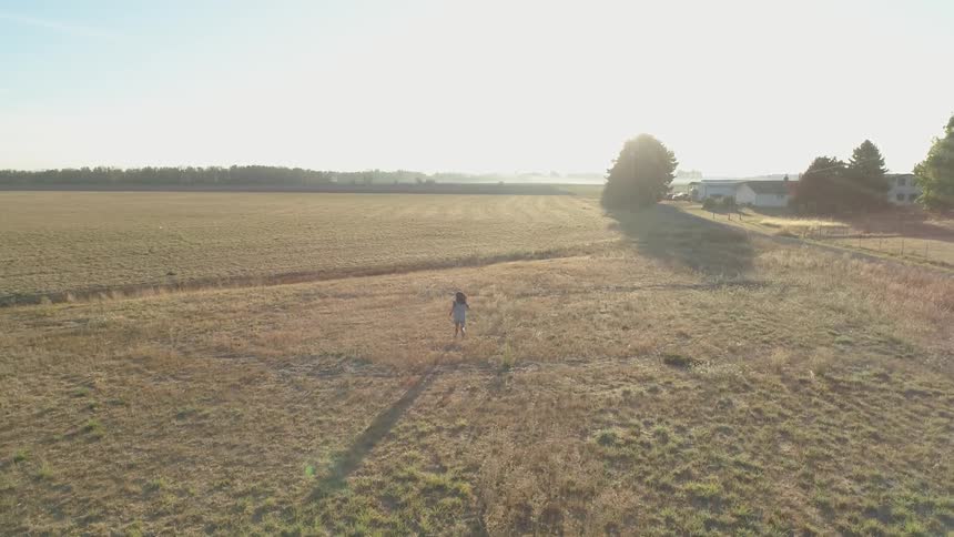 A person runs in a rural field on a sunny day