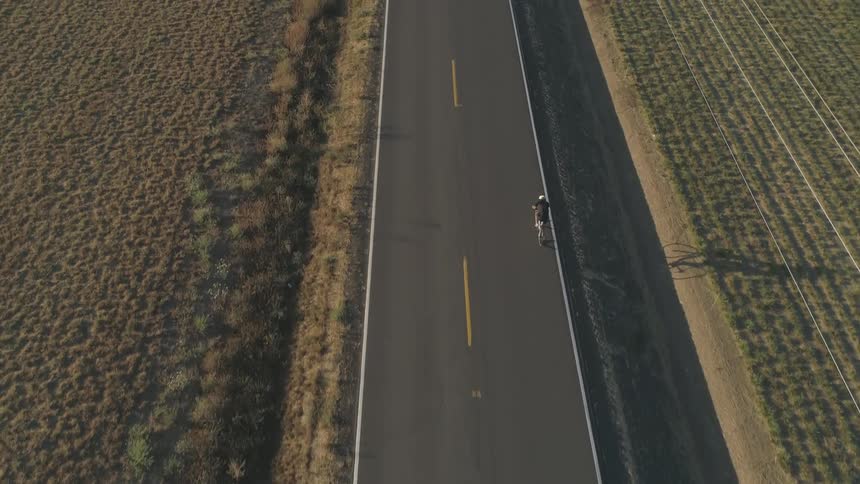 A person riding a bike down a country road