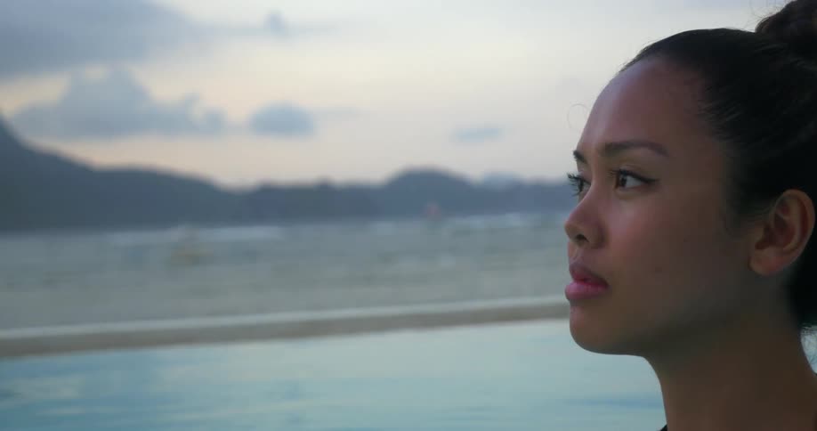 A young woman stands in deep water staring outwards