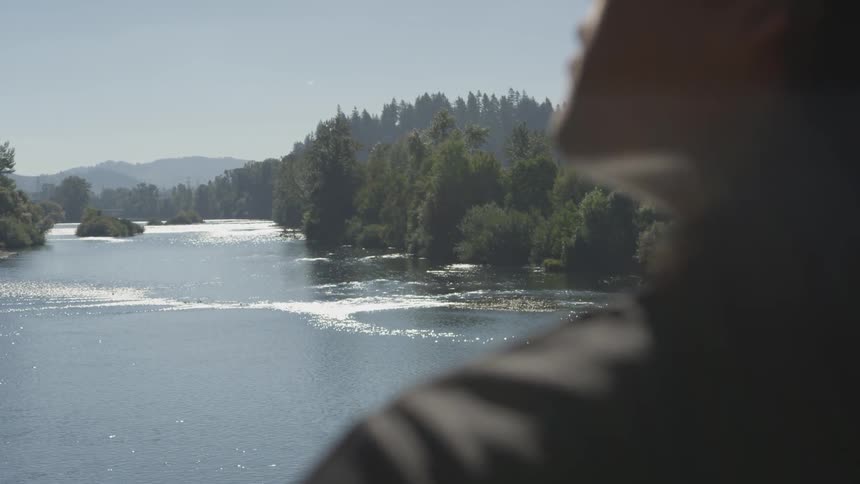 Person standing near a lake in the mountains reflecting on life