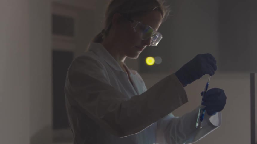 A woman tests chemicals in a lab