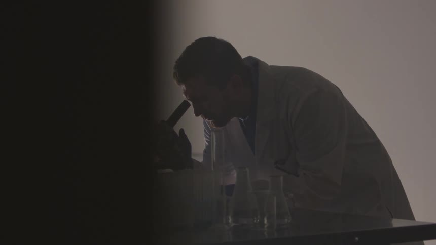 A man looks into a microscope