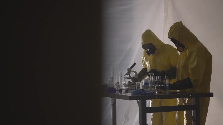 Men in protective suits work in lab