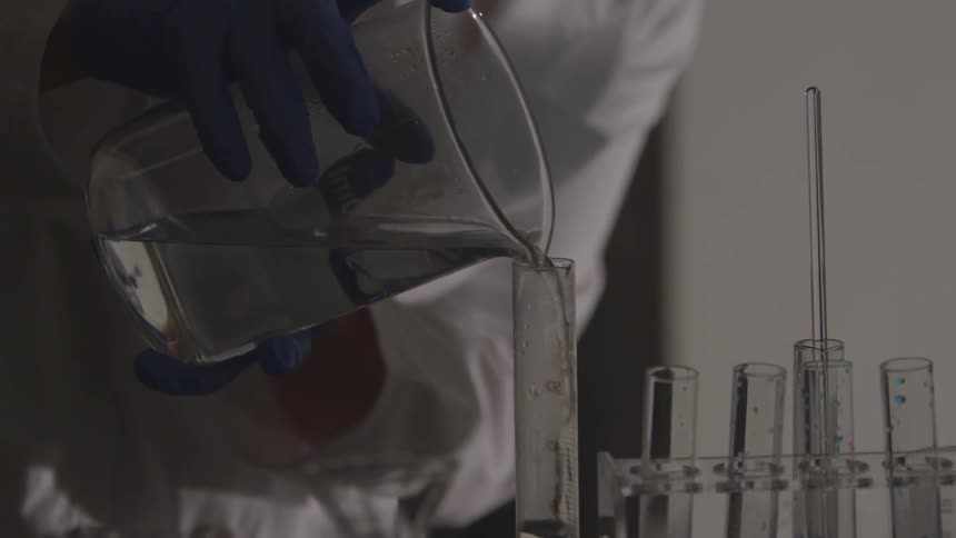 A scientist pouring liquid into a test tube
