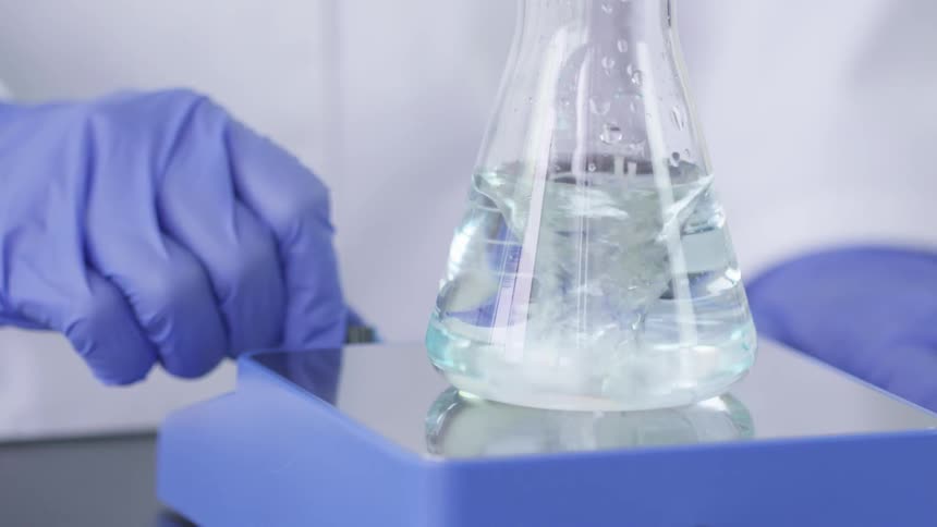 A scientist stirring chemicals in a lab