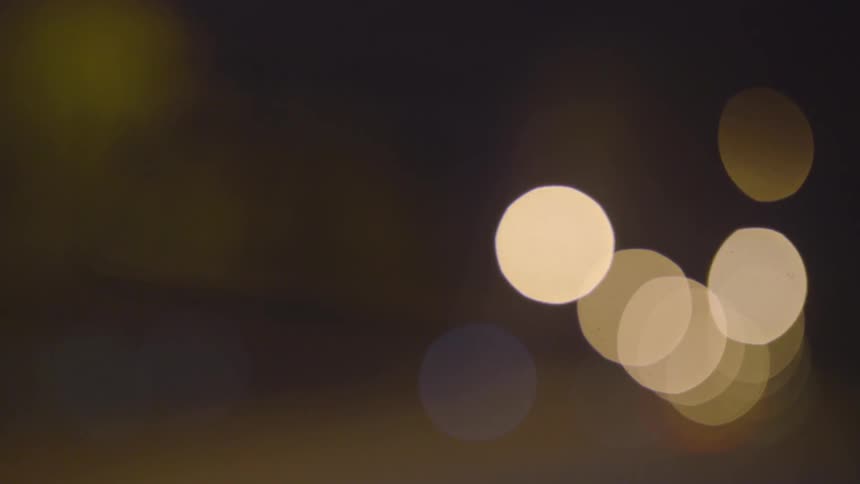 Lights flash outside at night creating a bokeh effect