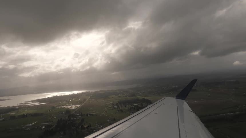 Sunlight peeking through thick clouds over an aircraft