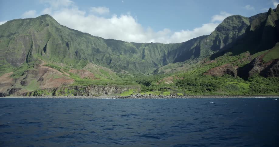 Water flows calmly in a waterbody next to vast mountains