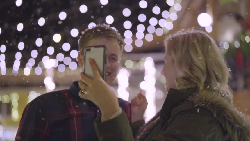 Girl showing man her phone