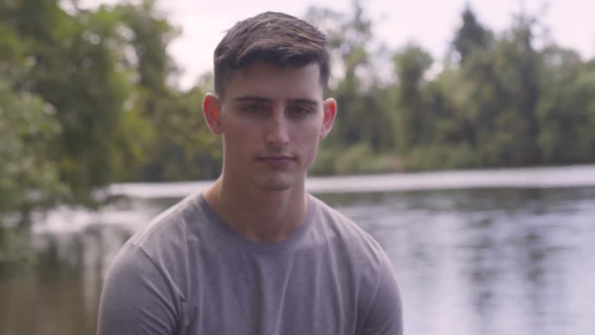 A boy sitting by the lake