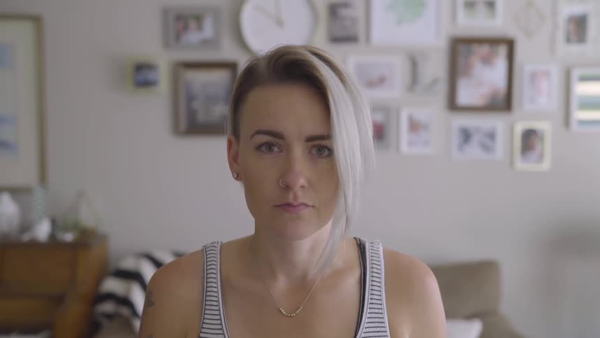 Woman in tank top looks up at camera