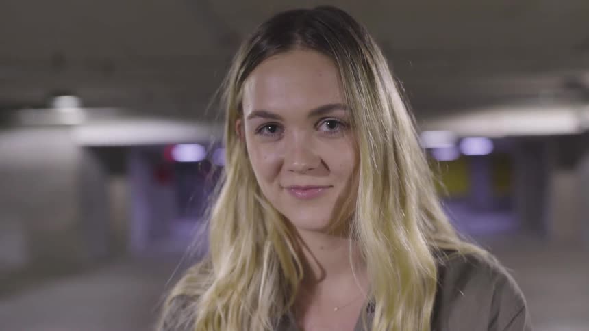 Blonde woman smiles and blinks her eyes