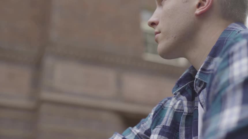 Man looking up next to a building