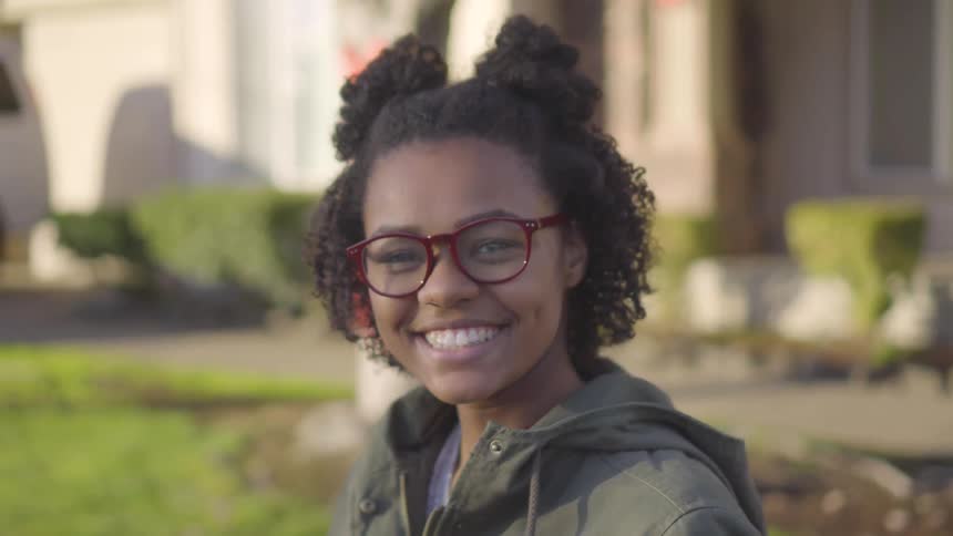 A young black woman laughs and smiles