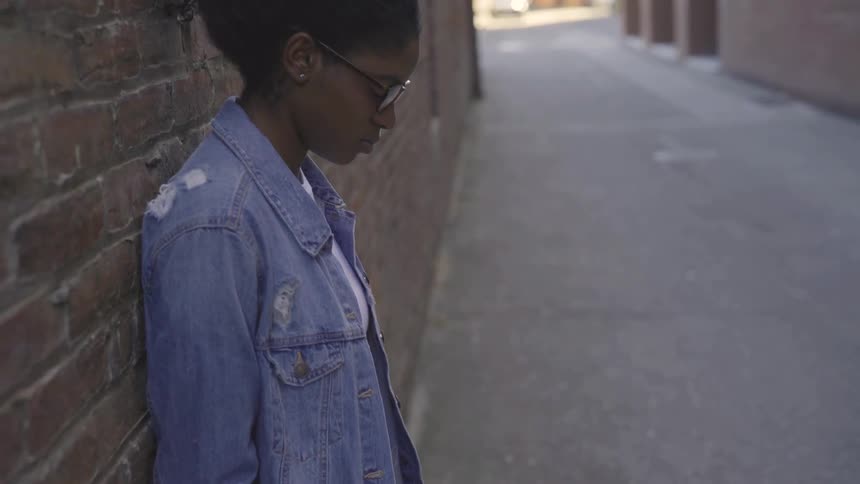 A woman looking down at the concrete