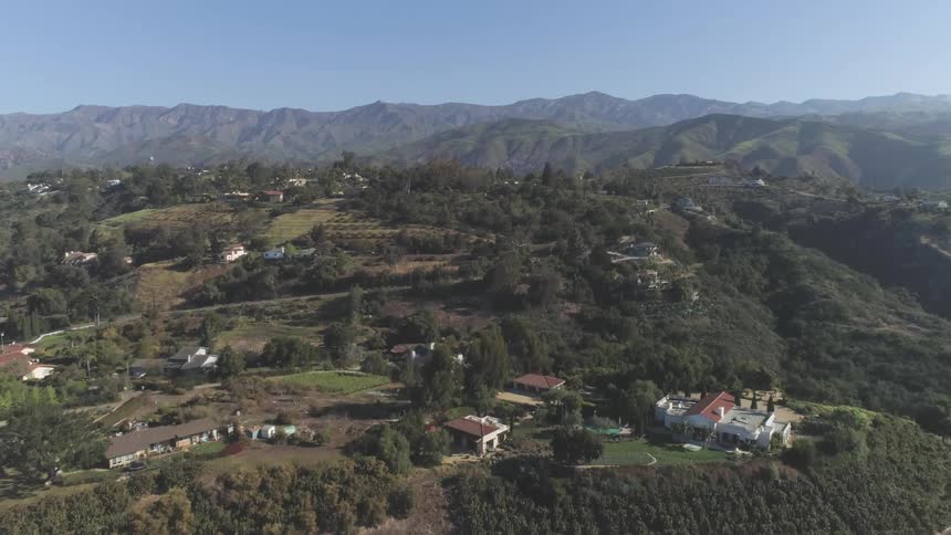 Aerial view of a neighborhood near a mountain range and wide open fields