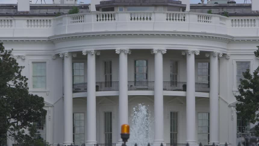 The camera looks towards the white house