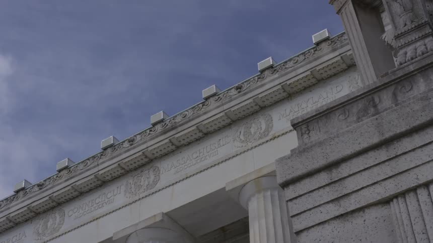 A government monument with pillars and the sky in the background