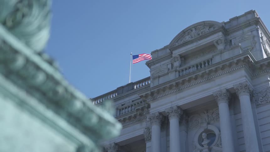 American flag waving above a historic building full of monuments