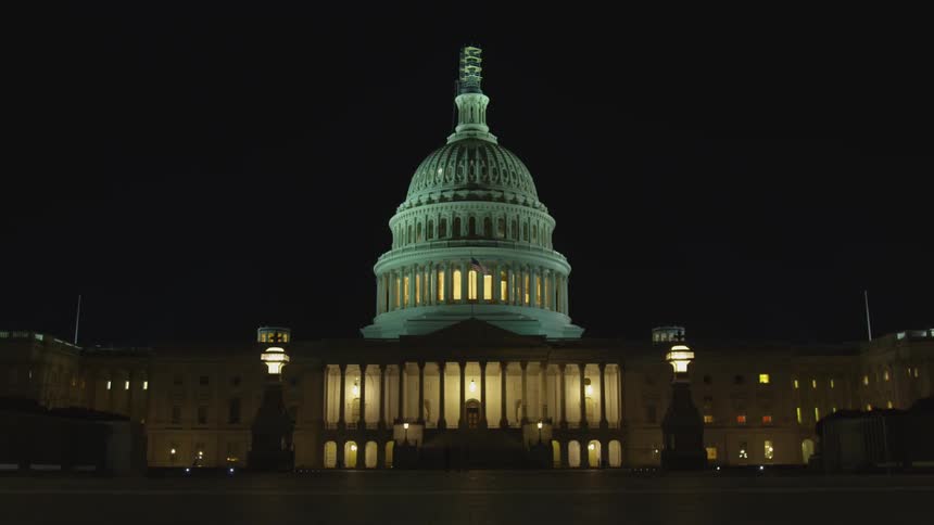 People walking around the capitol building at night