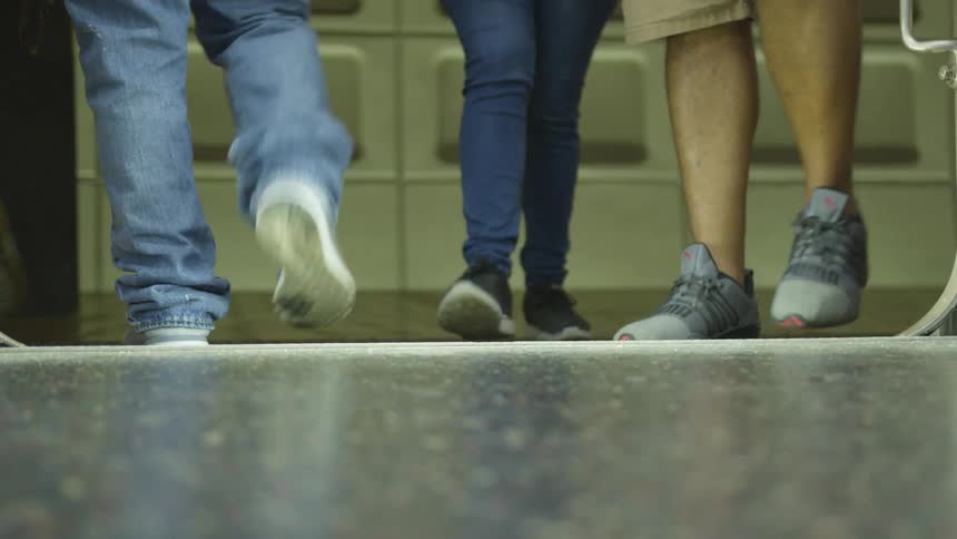 People walking in and out of an elevator