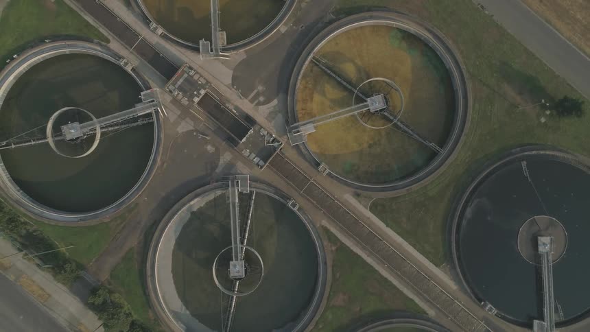 Camera flies over large water processing pools
